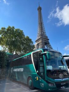 Ein Reisebus der Firma Globetrotter vor dem Eiffel-Turm in Paris